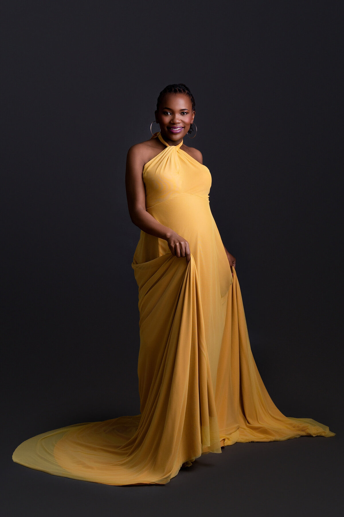 Golden maternity gown with dramatic train during studio session.