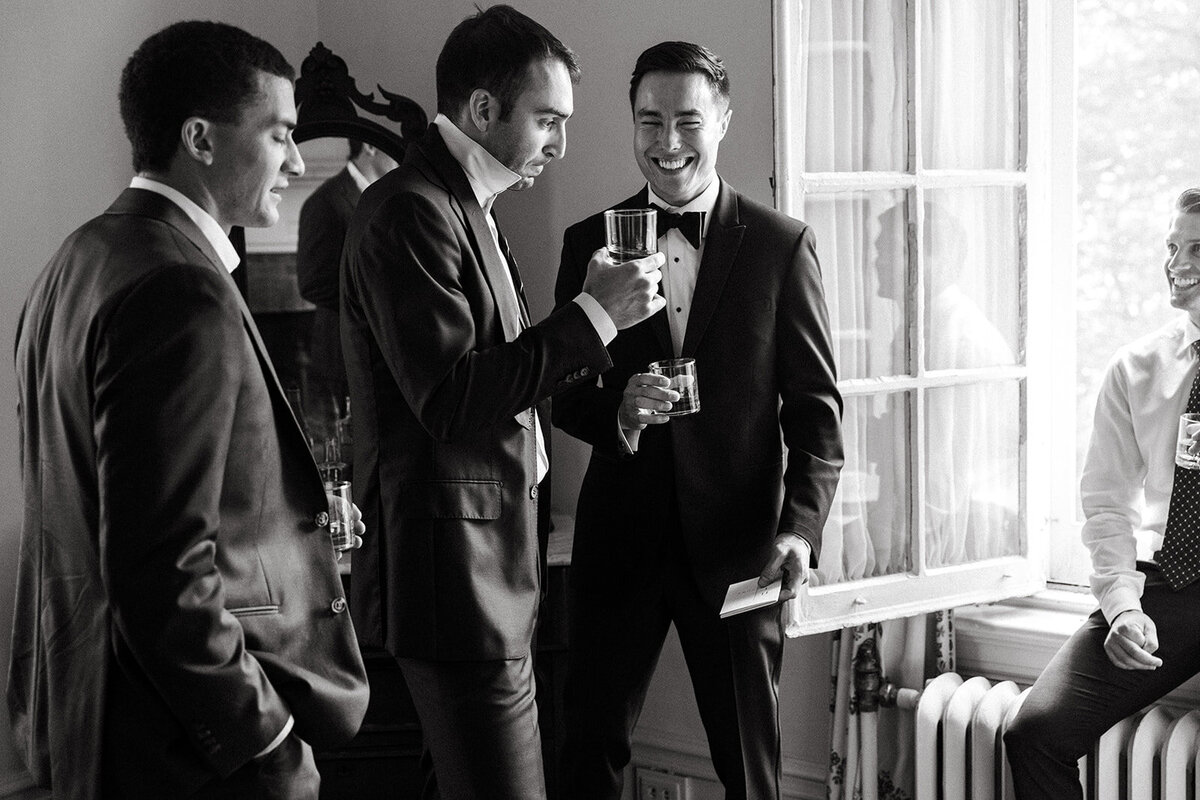 a group of men in suits enjoying champagne