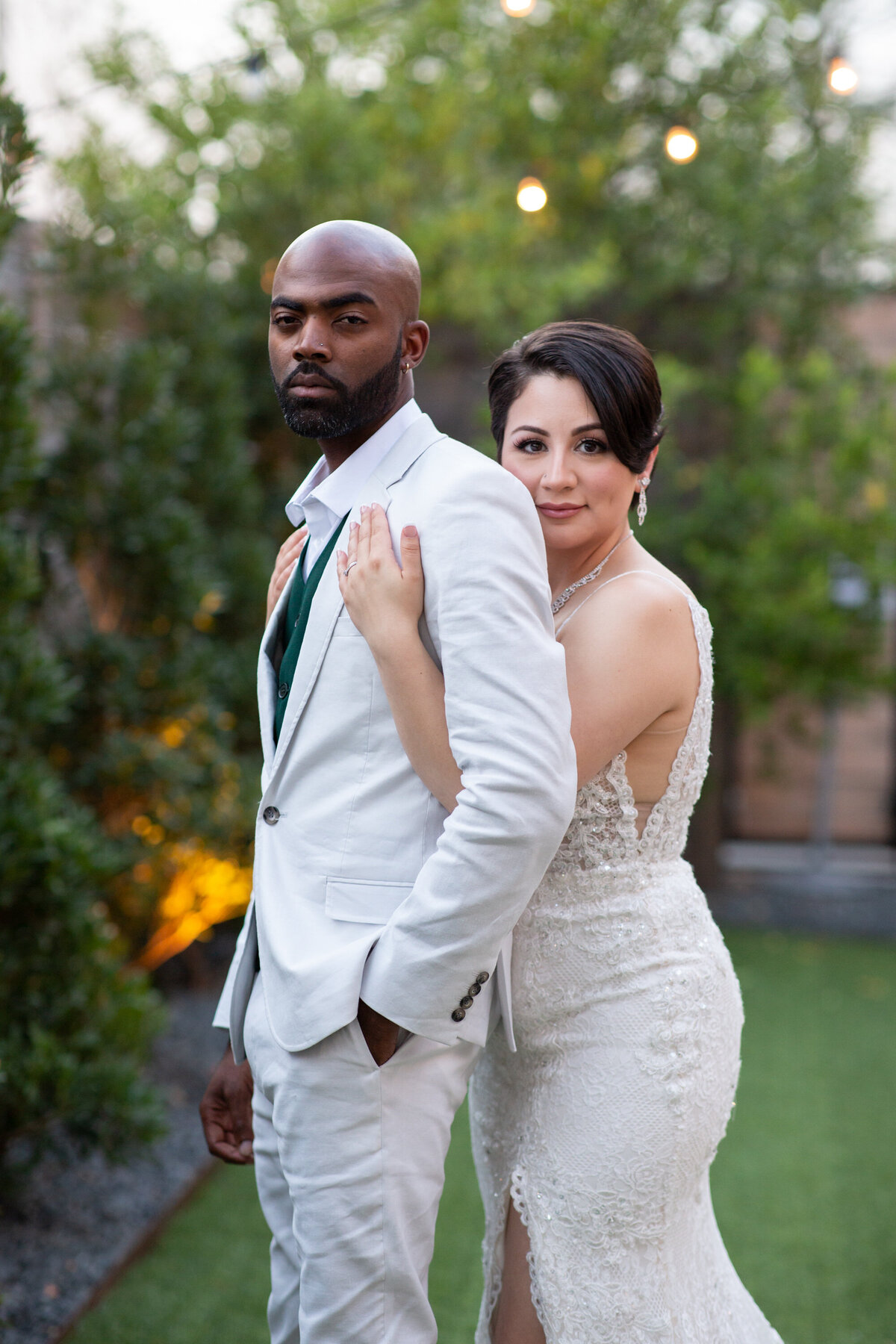 A bride and groom, captured by an Austin wedding photographer, posing for a photo in a garden.
