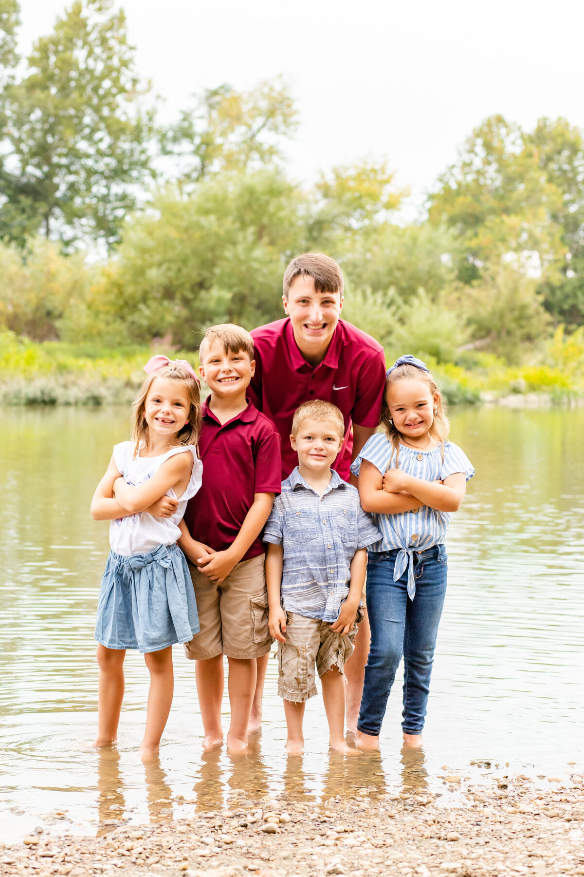 Kids standing in river smiling at camera