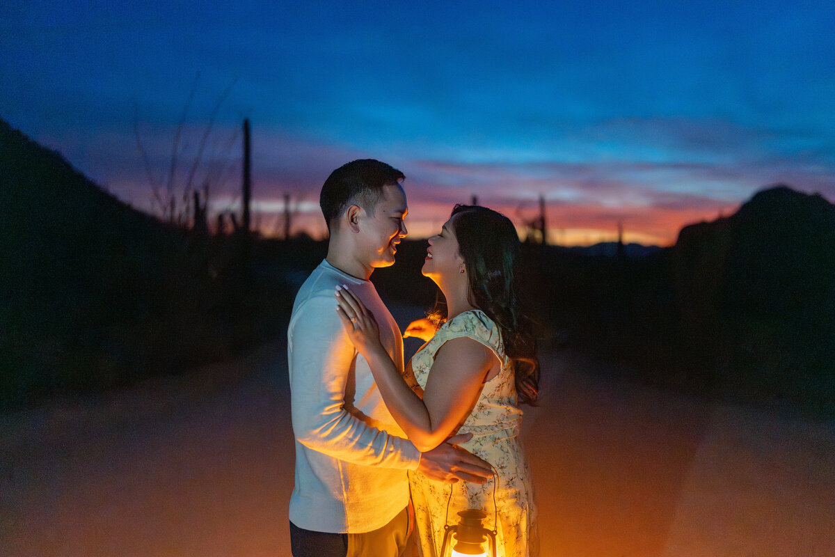 Tucson Saguaro Arizona Elopement with Bride Groom during Vibrant Sunset Blue Hour at Night embracing with lantern glow.
