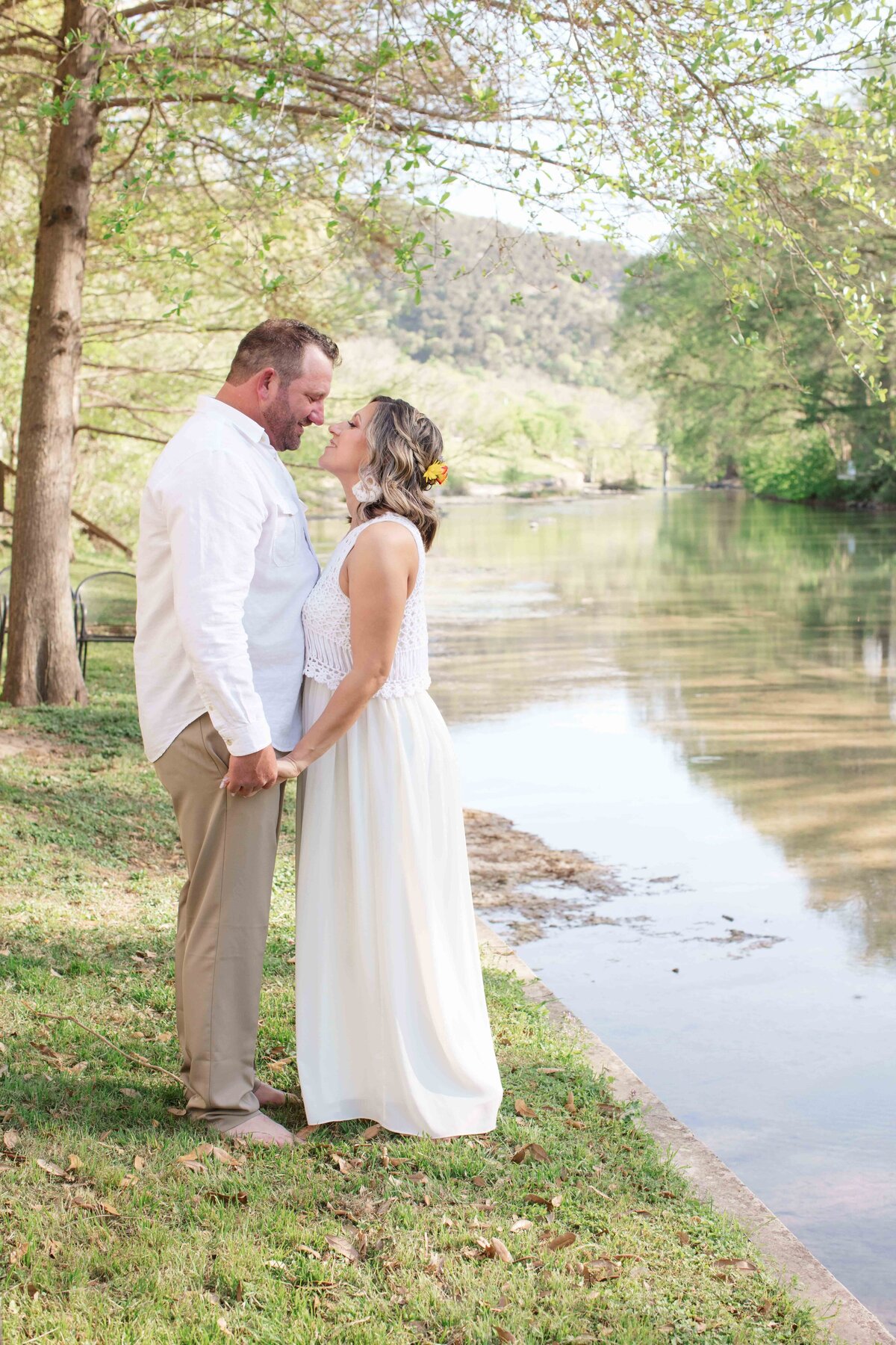 photographer captures portrait of couple by Guadalupe River in New Braunfels Texas for intimate wedding