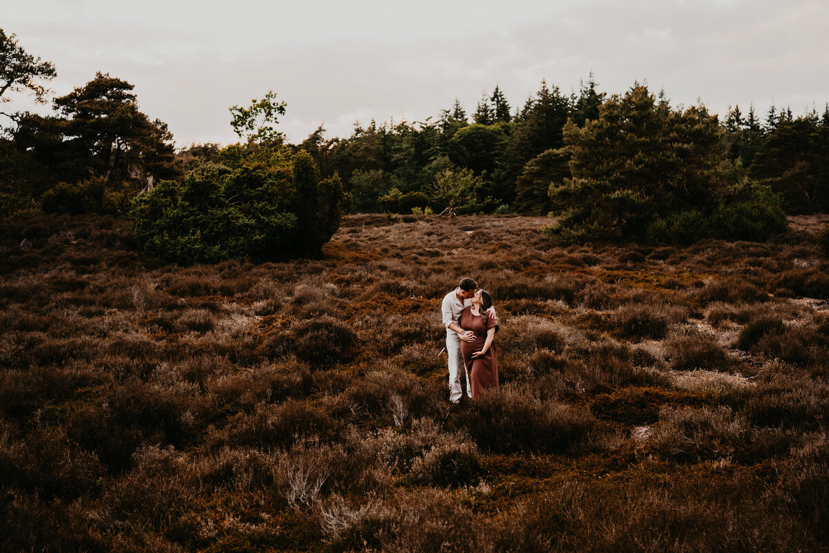 zwangerschapsshoot met zonsondergang op de heide in Drenthe