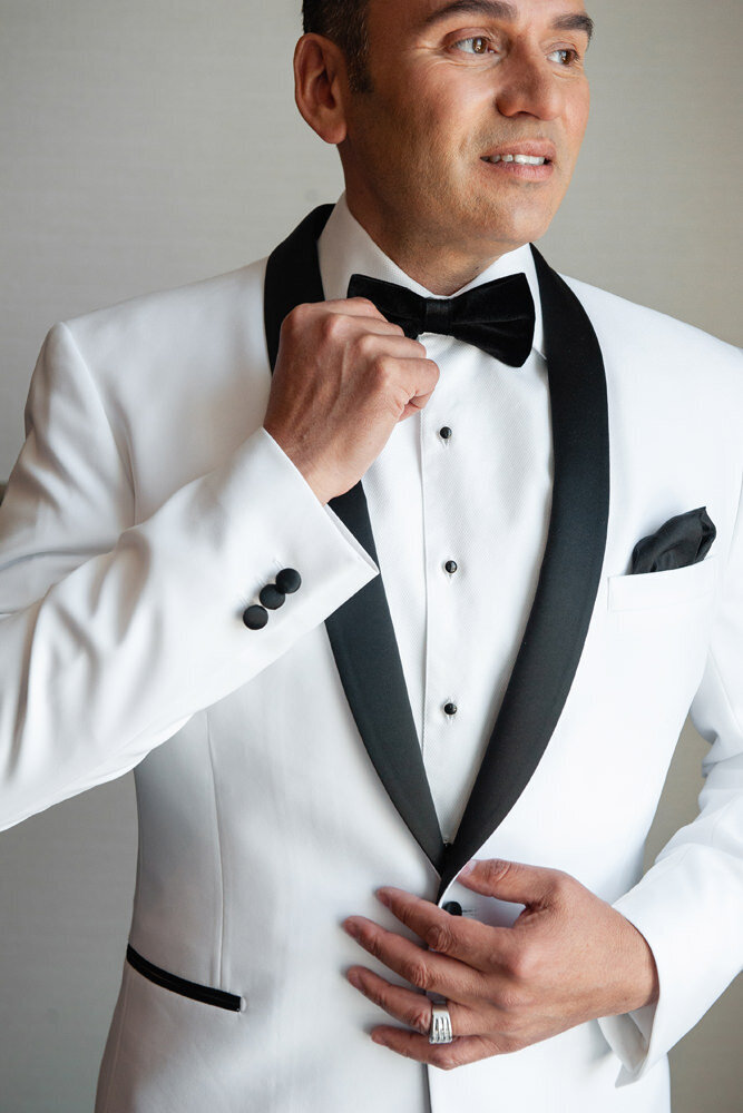 A groom adjusting his tie