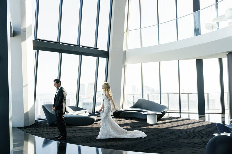 Miami couple's First Look moment in a contemporary skyscraper lobby