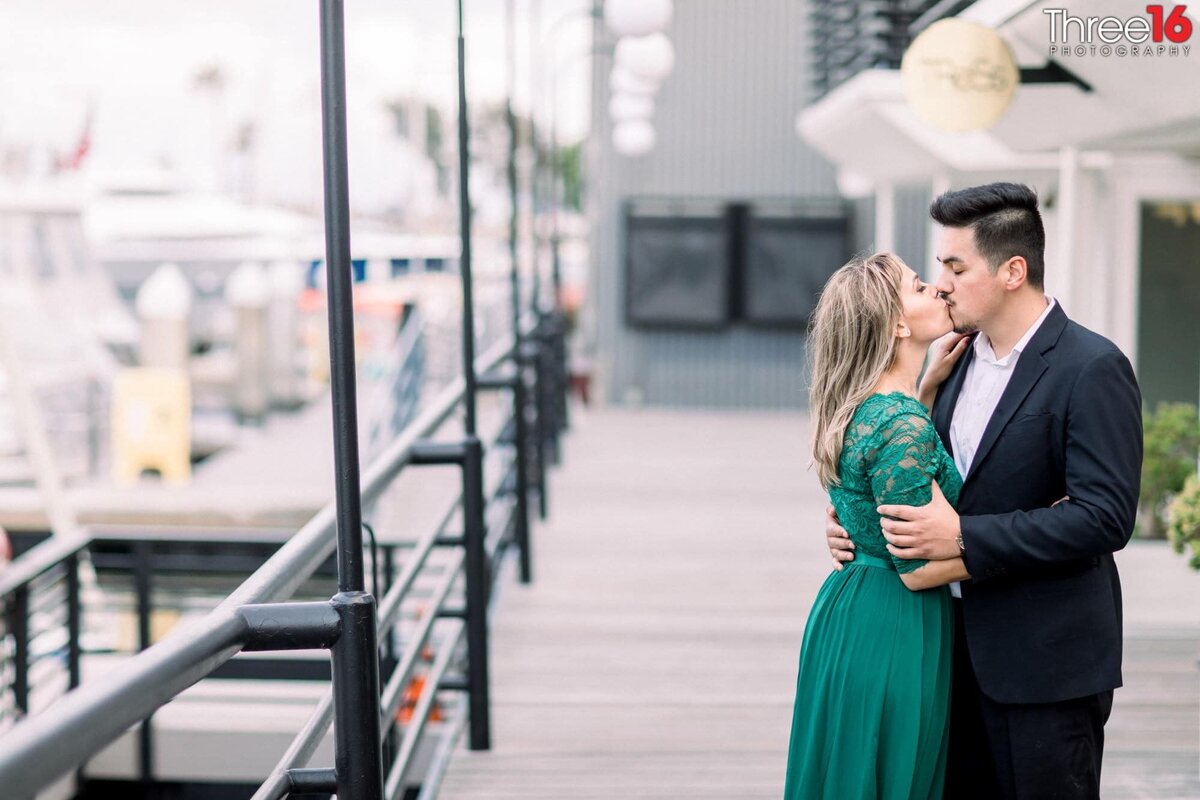 Engaged couple share a kiss on the balcony at the Lido Marina Village