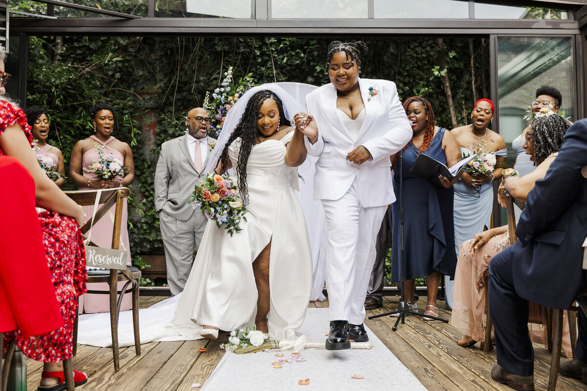 LGBTQ couple jumps the broom at their wedding