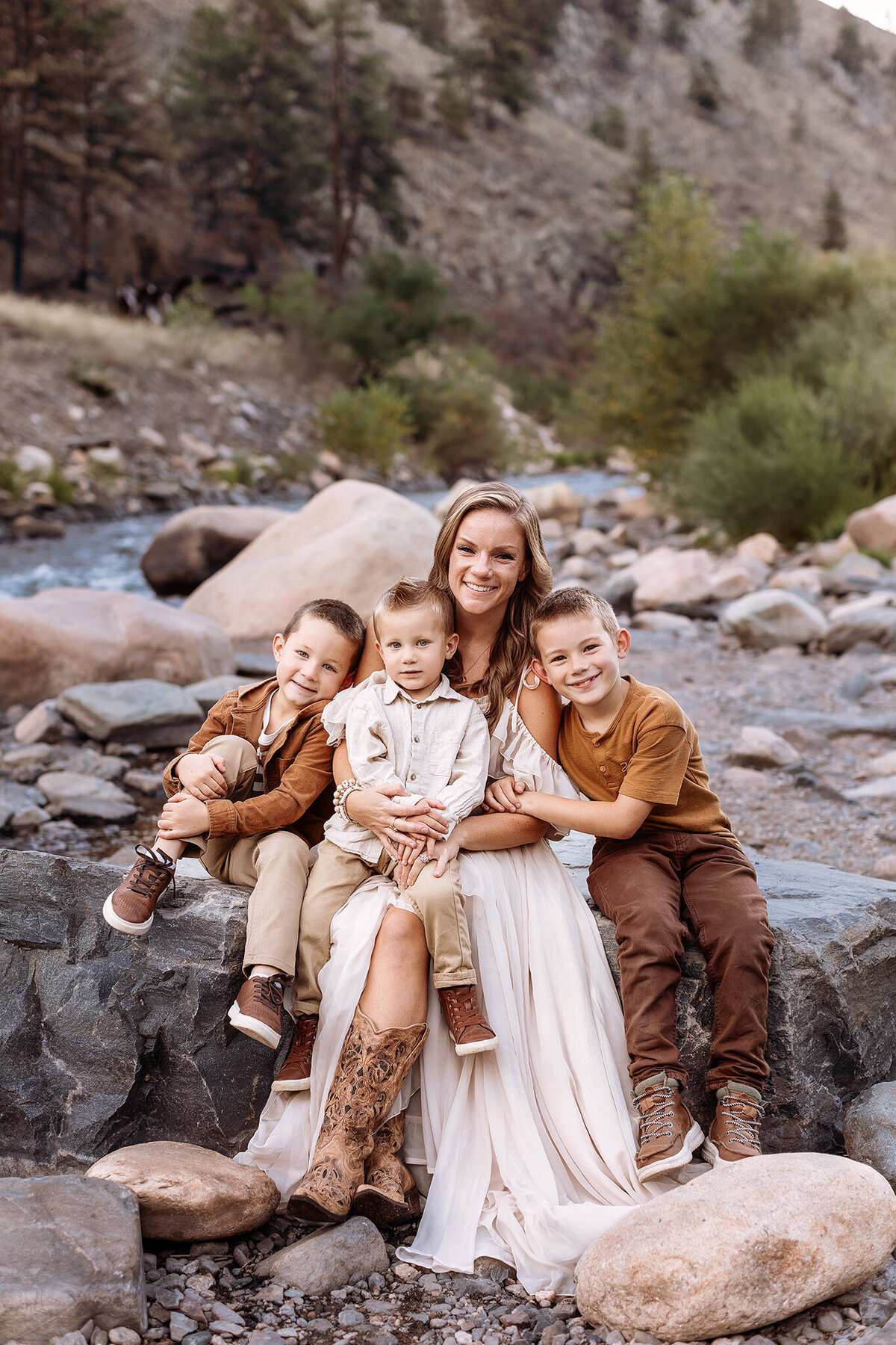 mom hugging her three boys long the river in ester park for their family photos