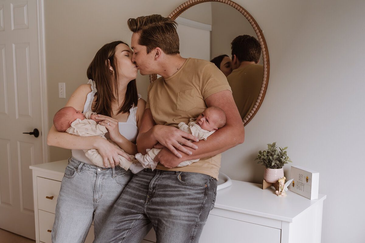 parents holding twin babies