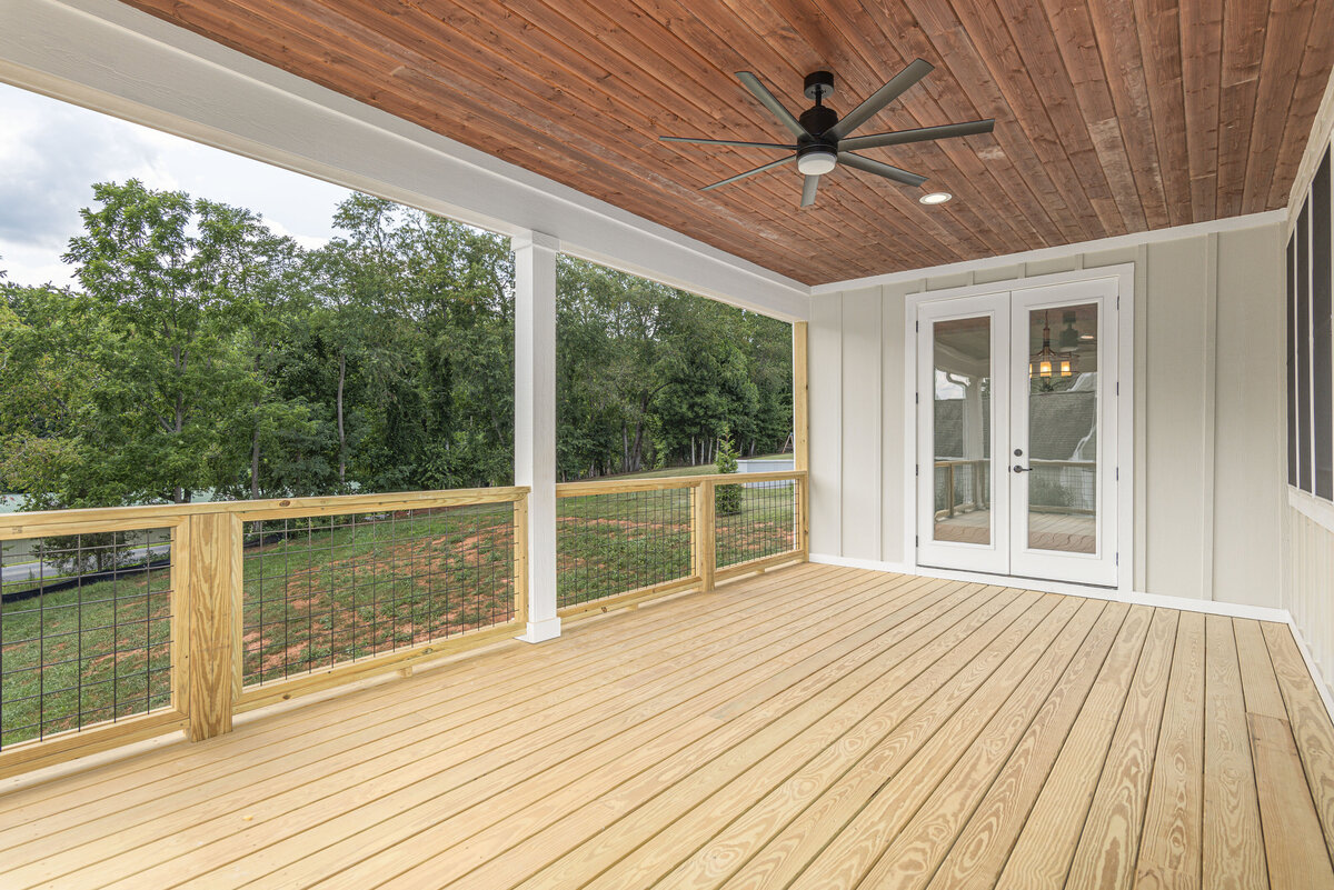 A wooden porch with a ceiling fan and wood flooring in Asheville