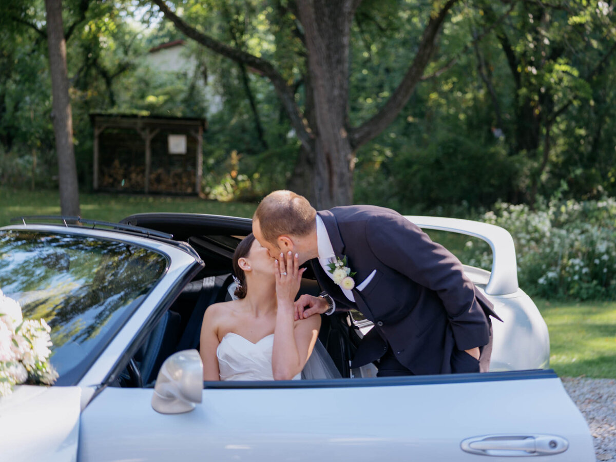 Bride and groom in their favorite sports car on their wedding day.