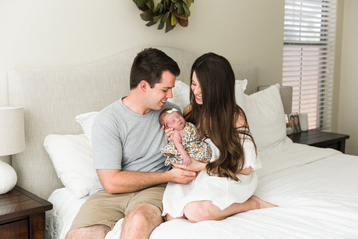 mom and dad cradle newborn baby