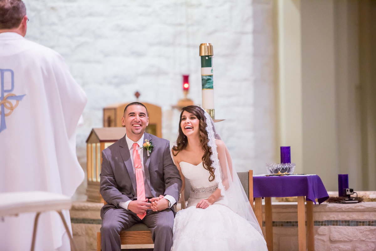 bride and groom laughing with priest during wedding ceremony at St. Dominics Catholic Church in San Antonio
