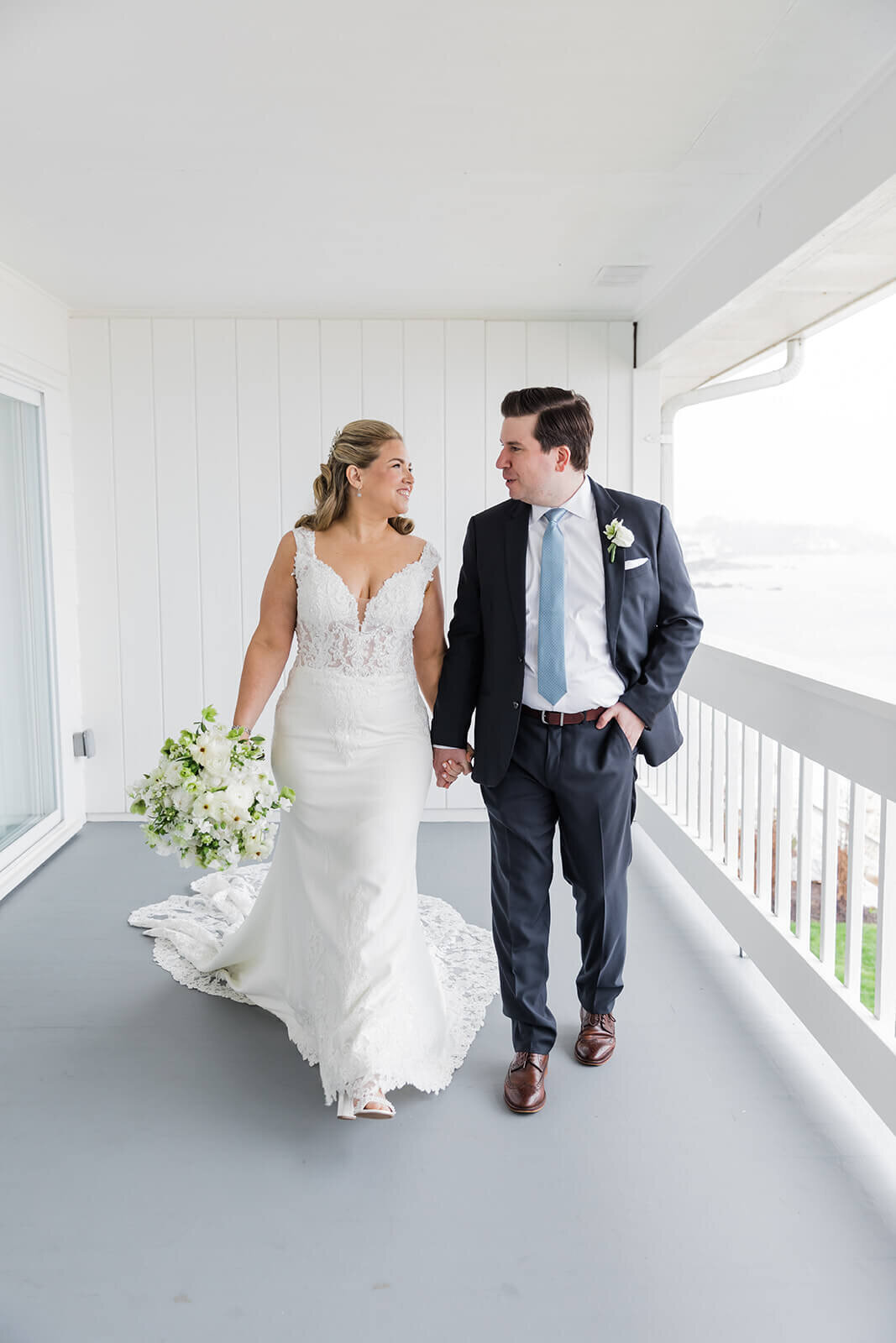 Bride and groom walking along balcony at Long Island wedding New York