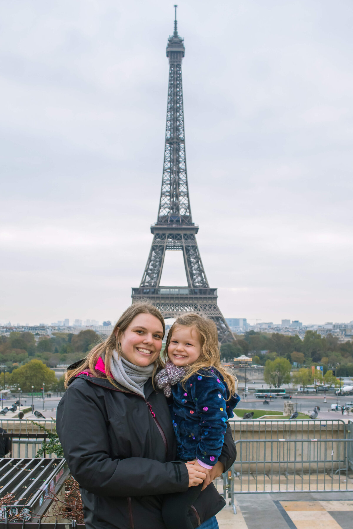 A picture of me and my daughter posing in front of the Eiffel Tower in Paris.