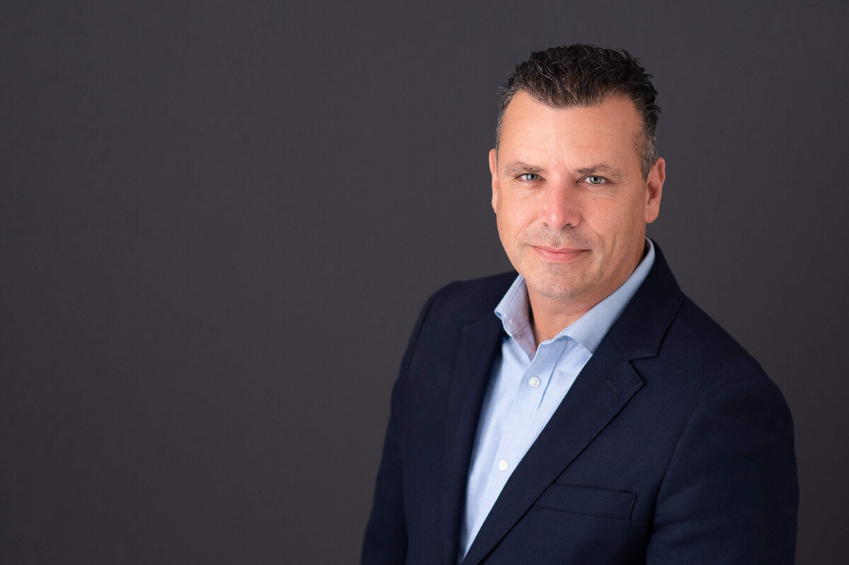 casual Ottawa headshot taken in  studio of a male in a blue shirt and blazer by JEMMAN Photography Commercial