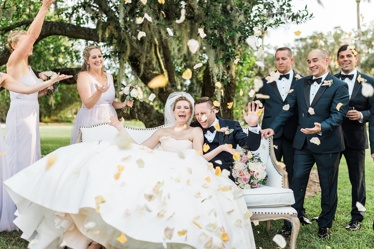 bridal party toss petals over newlyweds