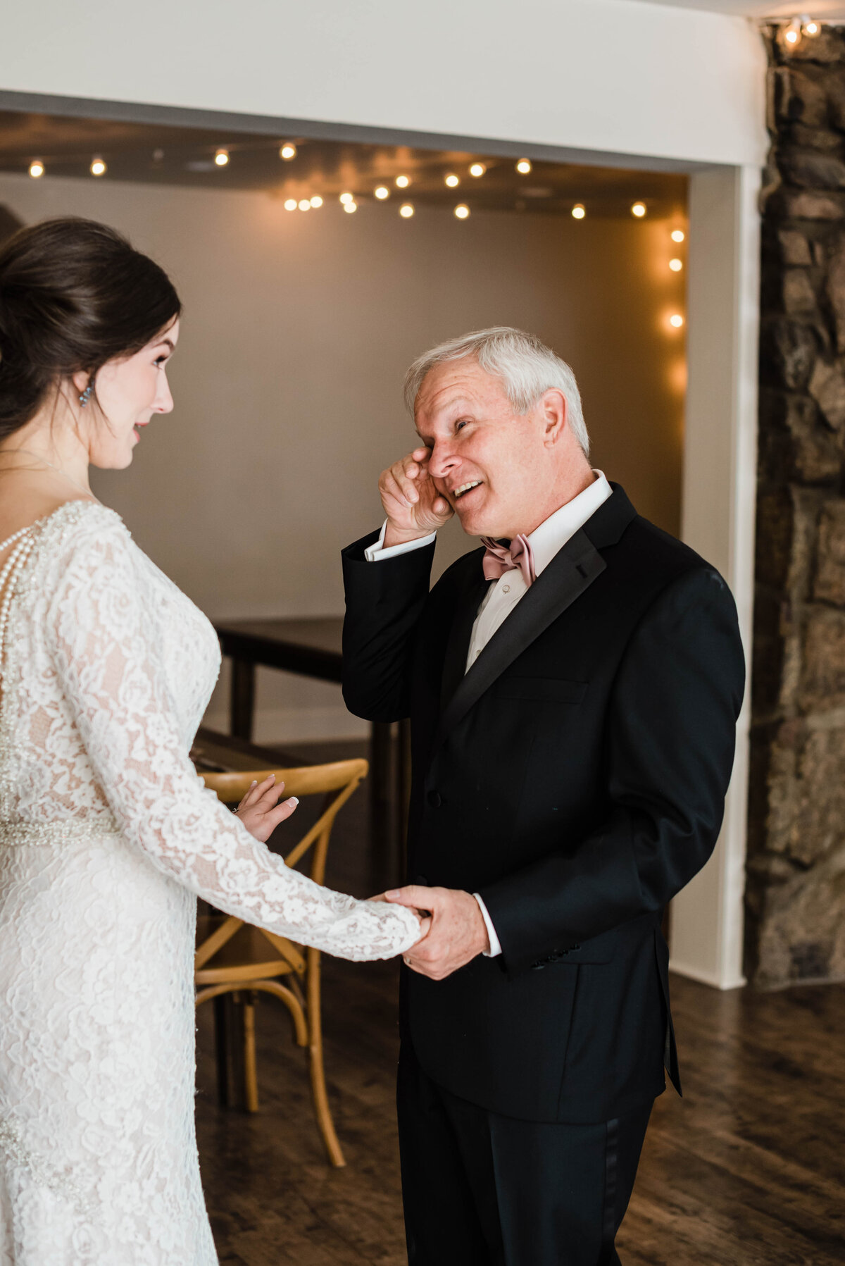 Father of the bride wipes a tear from his eye as he see his daughter for the first time right before her wedding day at Boulder Wedgewood