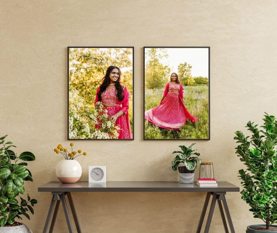 two framed senior pictures hanging side by side over a small table.