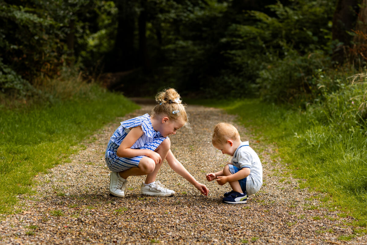 gezinsfoto broer en zus spelen met steentjes