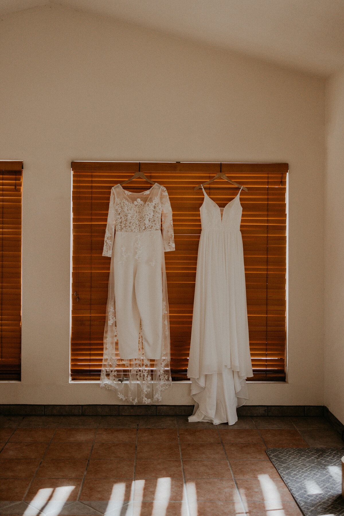 bridal gown and bridal jumpsuit hanging together