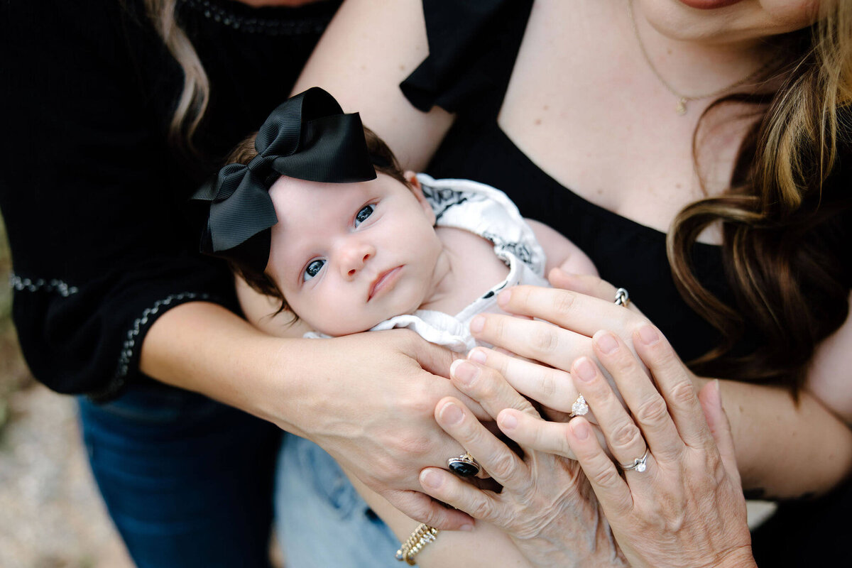 generational family pictures. Five generations all laying hands on newborn baby in Longview, Texas