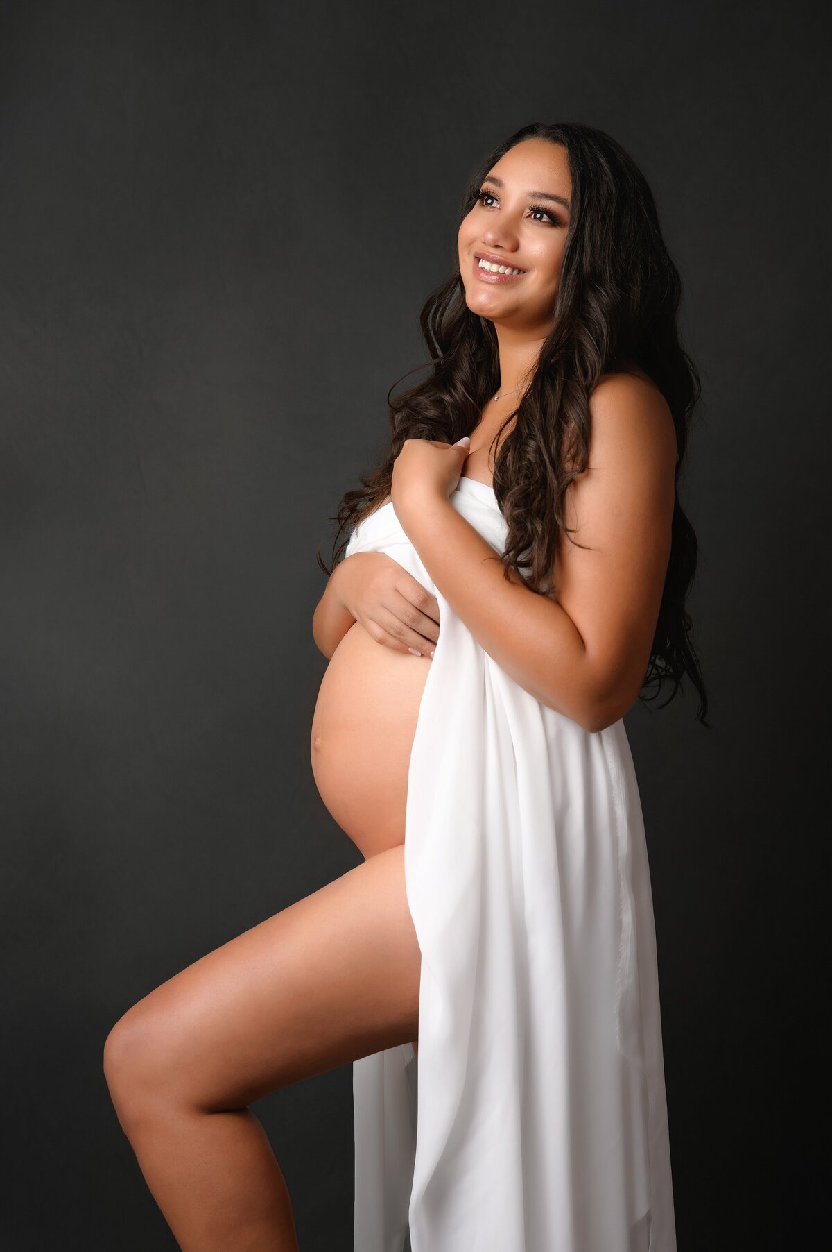 Happy mom to be poses for intimate maternity photoshoot in West Palm Beach studio.