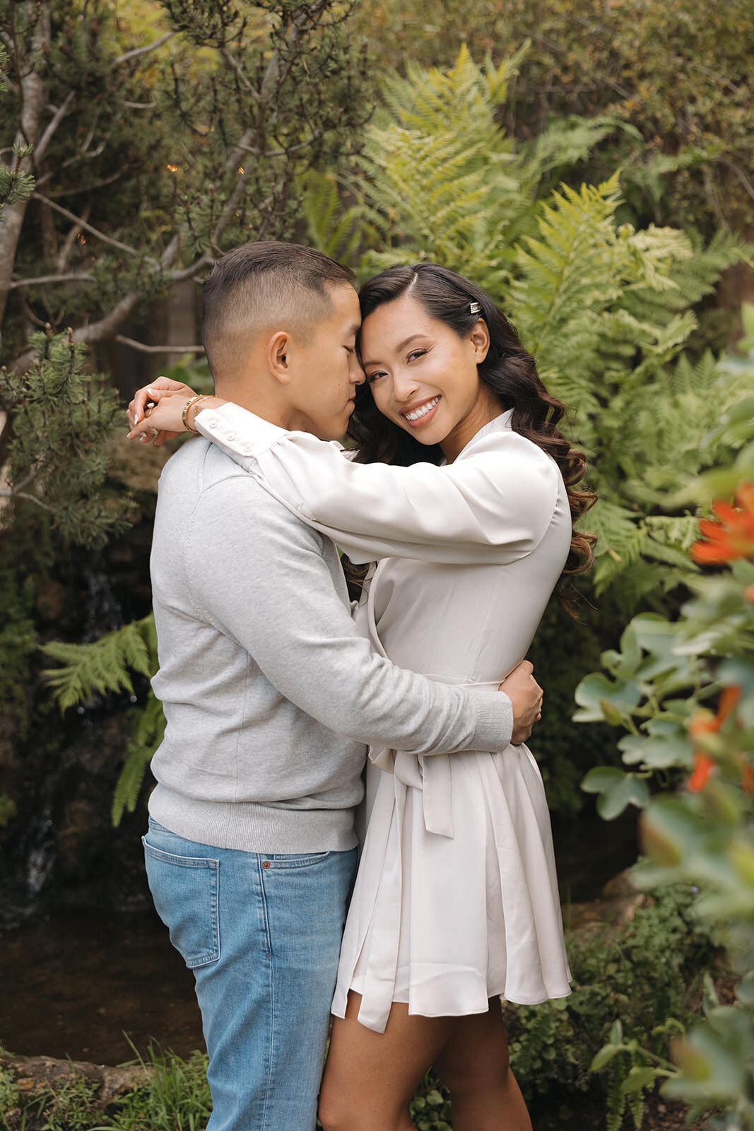 Engaged couple hugging in a garden