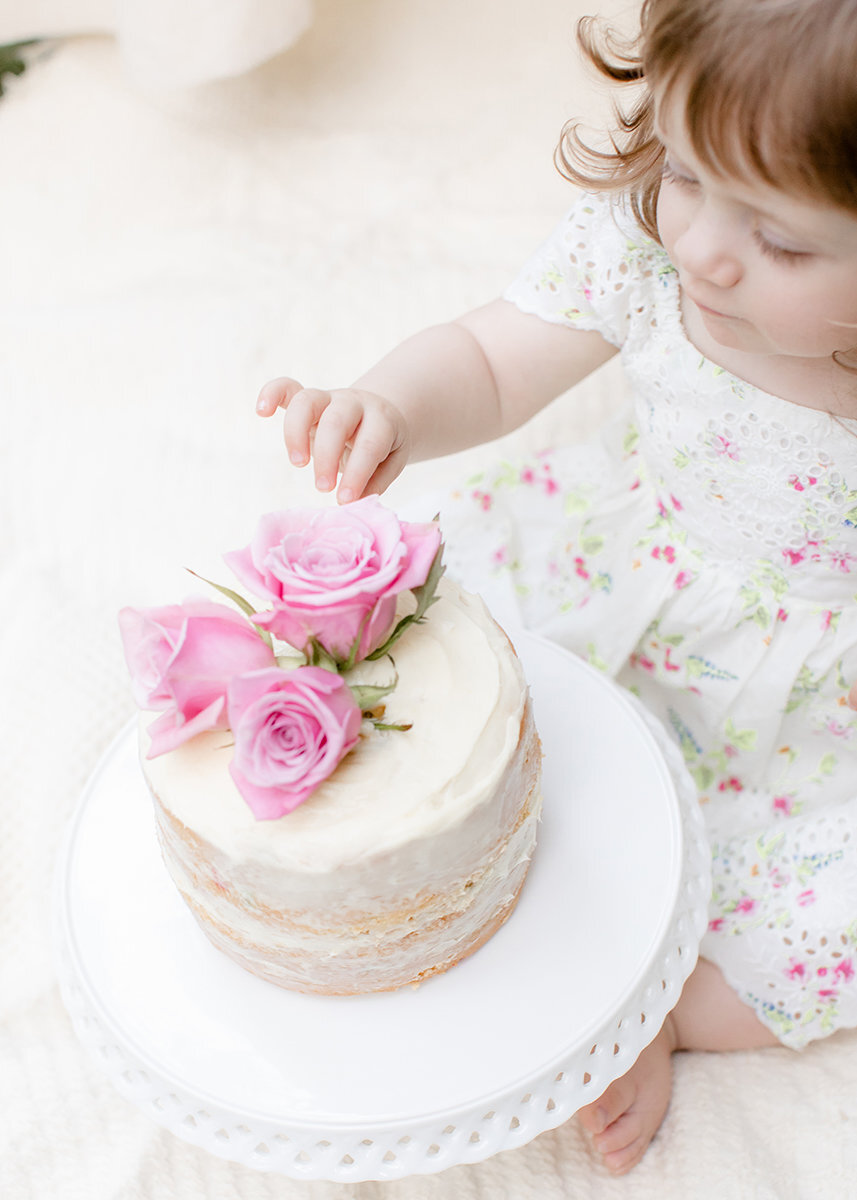 little-girl-touching-rose-cake-smash