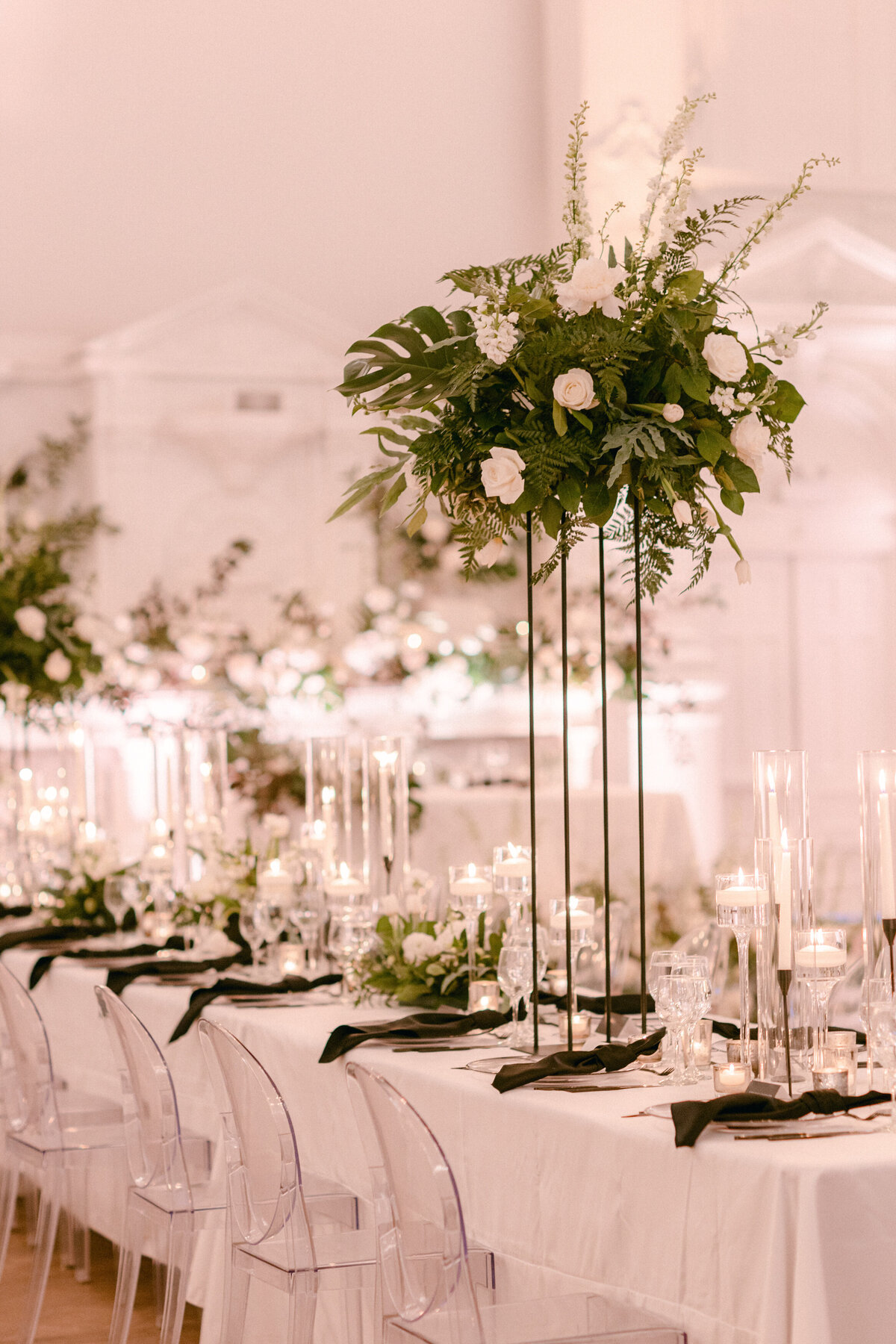 A Maison Principale wedding reception showcases elevated and low floral table centerpieces with exotic greenery.