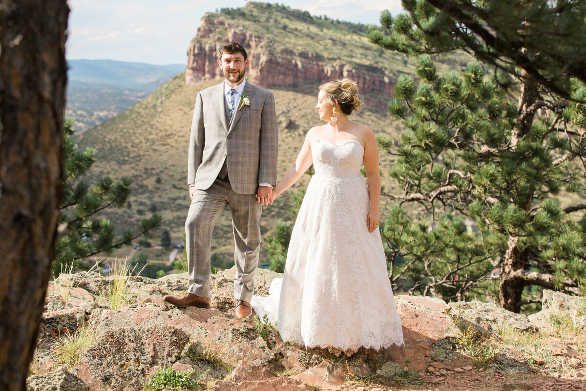 A wedding couple pose for photos in Lyons Colorado at Lionsgate Manor with beautiful scenery behind them