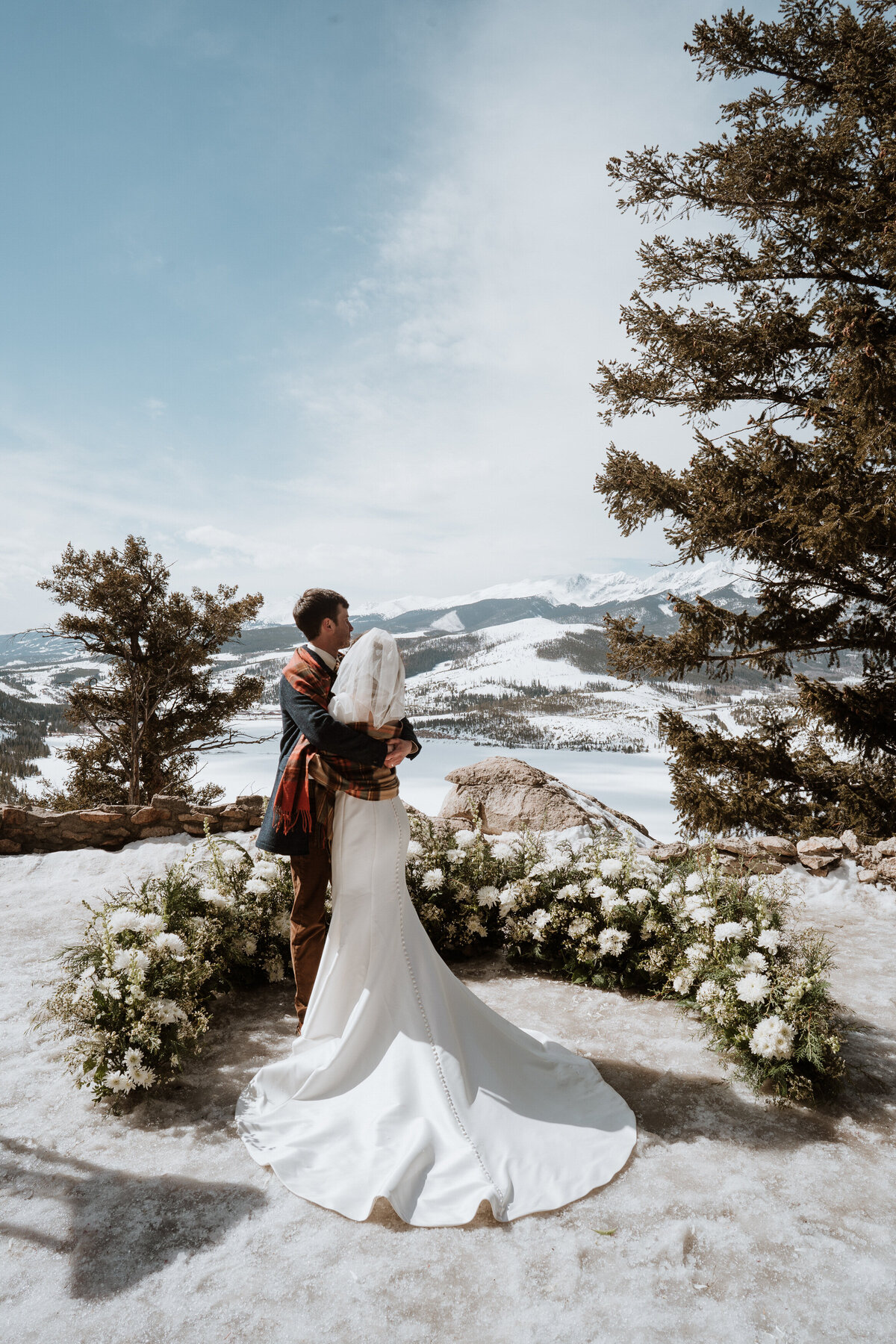 Bride and groom embrace during snowy mountaintop elopement at Sapphire Point near Breckenridge.