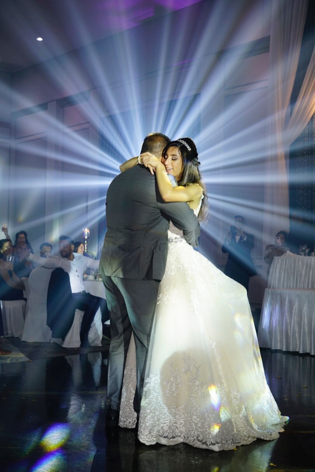 The bride shares a heartfelt dance with her father, creating a touching and memorable moment. The image captures their close connection and the emotional significance of the father-daughter dance, showcasing their joy and the special bond they share on this significant day.