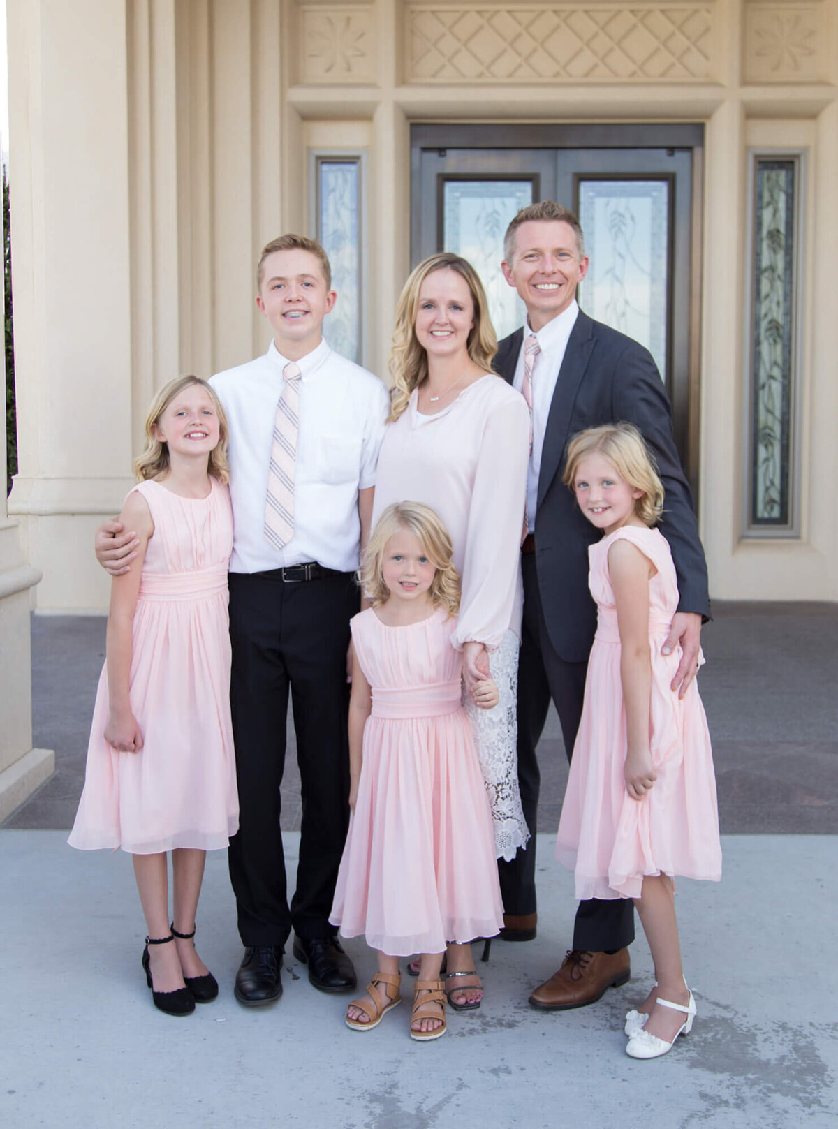 a family in pink and white at an lds temple wedding