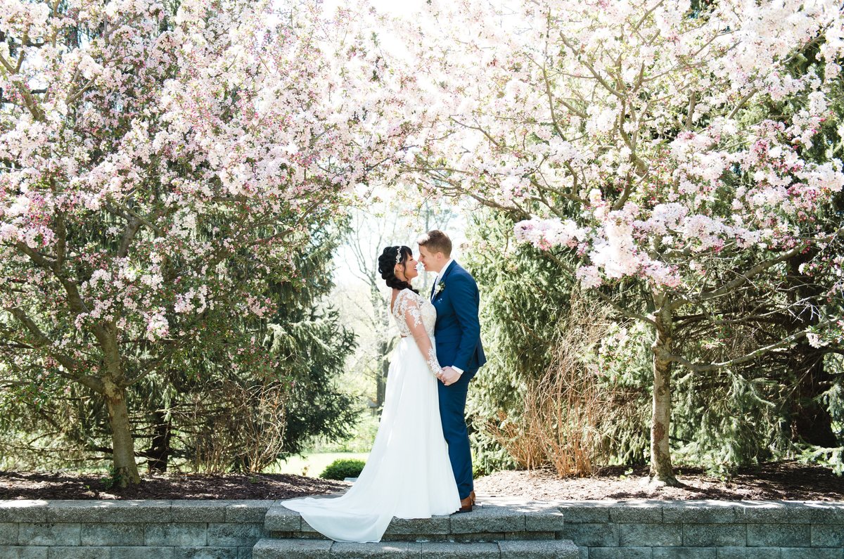 bride and groom kissing under jasmine trees
