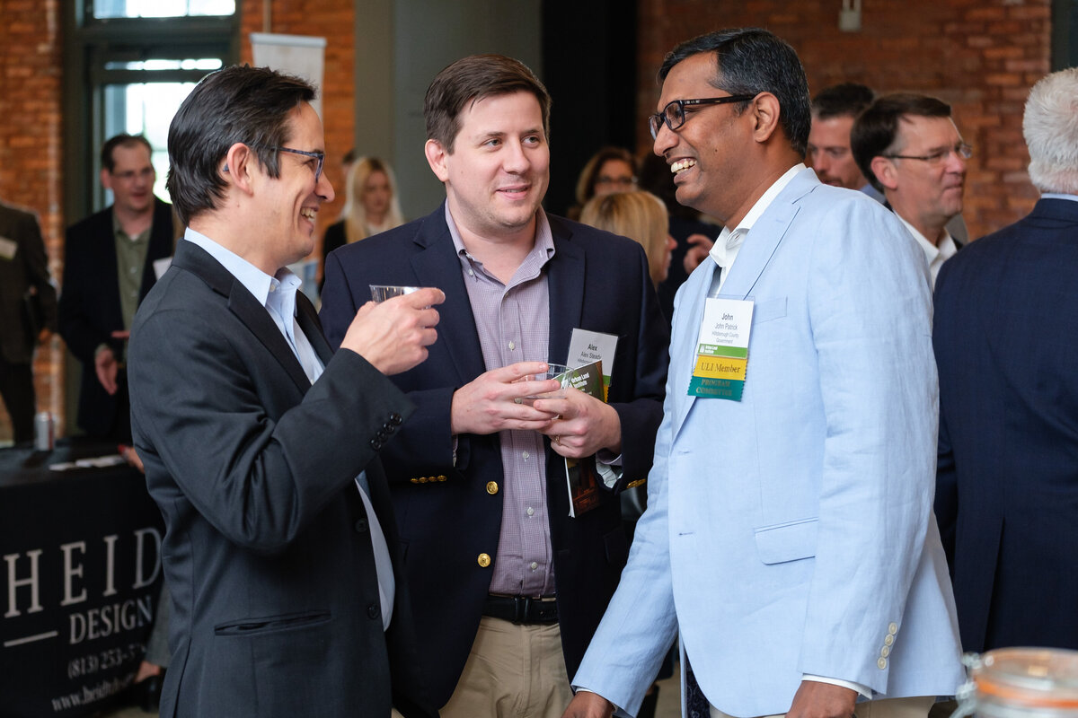 Three attendees of the conference enjoy drinks during the social hour to meet and greet their peers