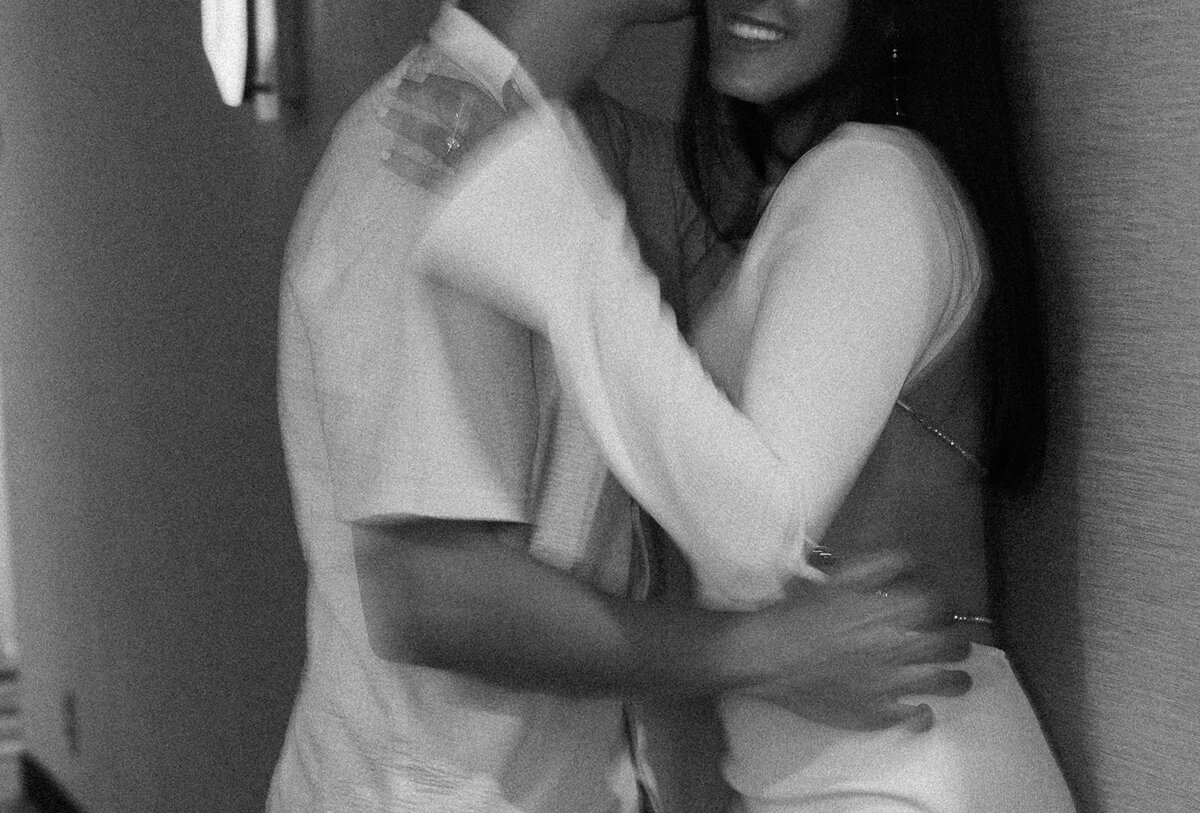 A black and white hallway portrait of Rebecca and Graysen wrapped in each other’s arms, capturing their deep connection during their Florida engagement session.