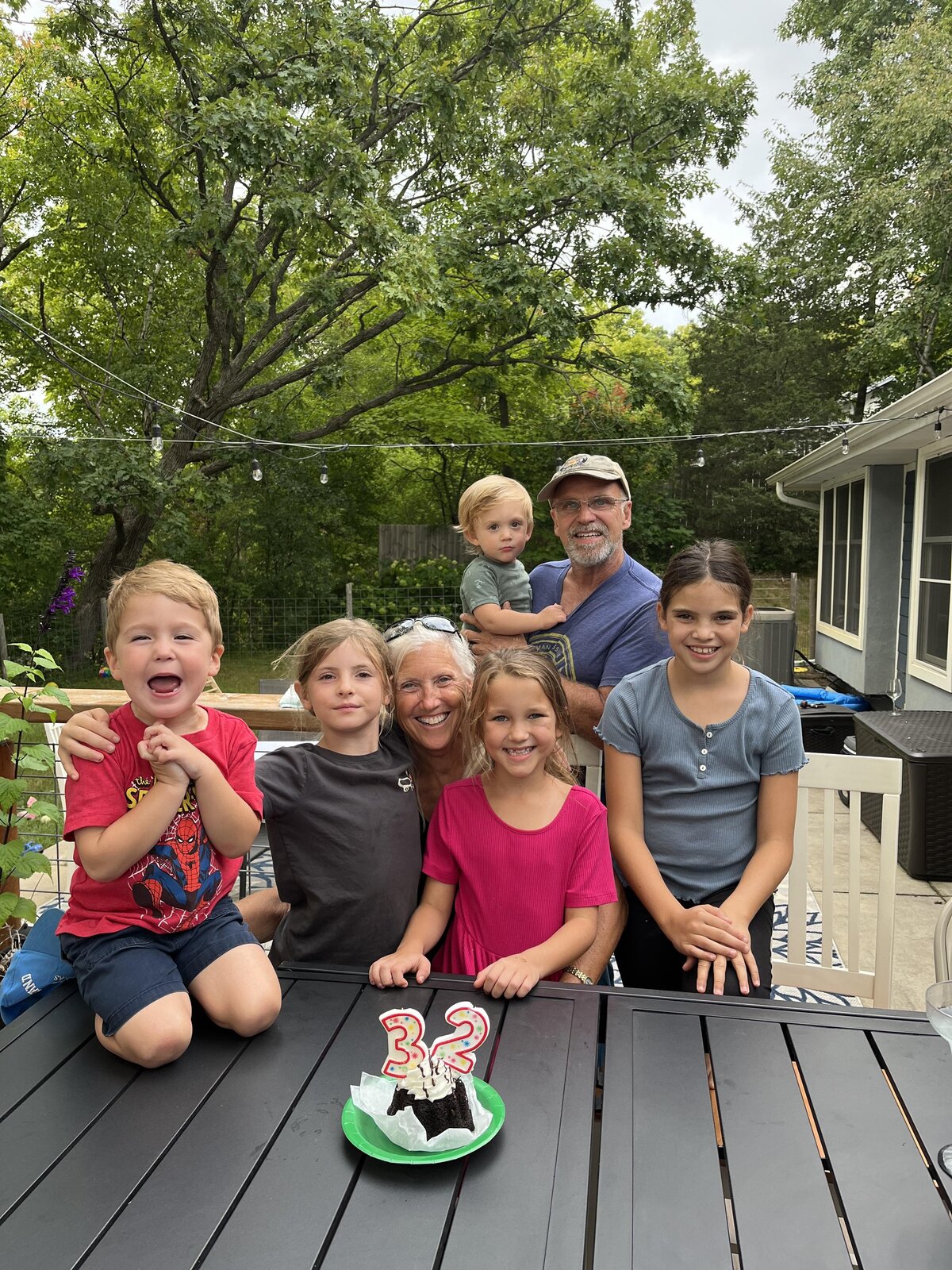 grandma and grandpa with their grandkids outside for a birthday party