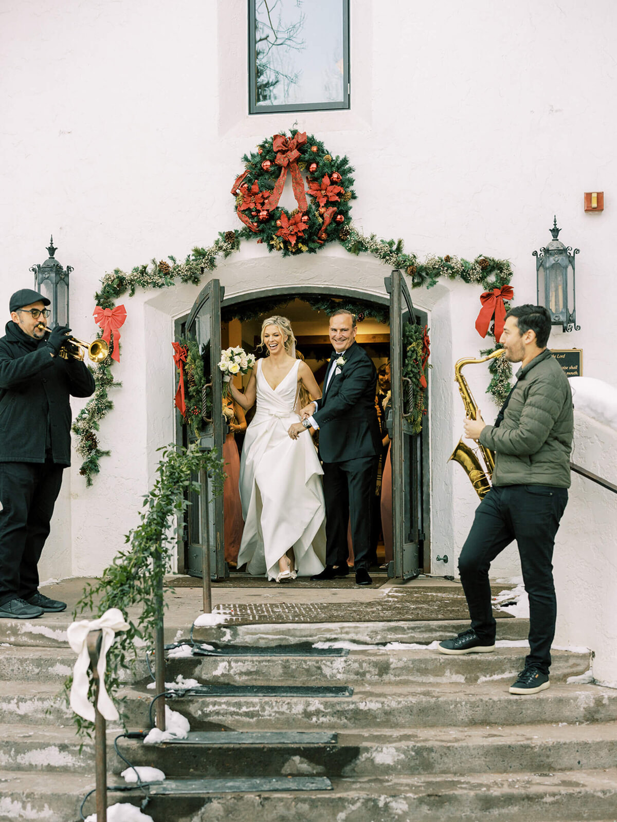 Bride and groom walking out of the chapel to saxophone music
