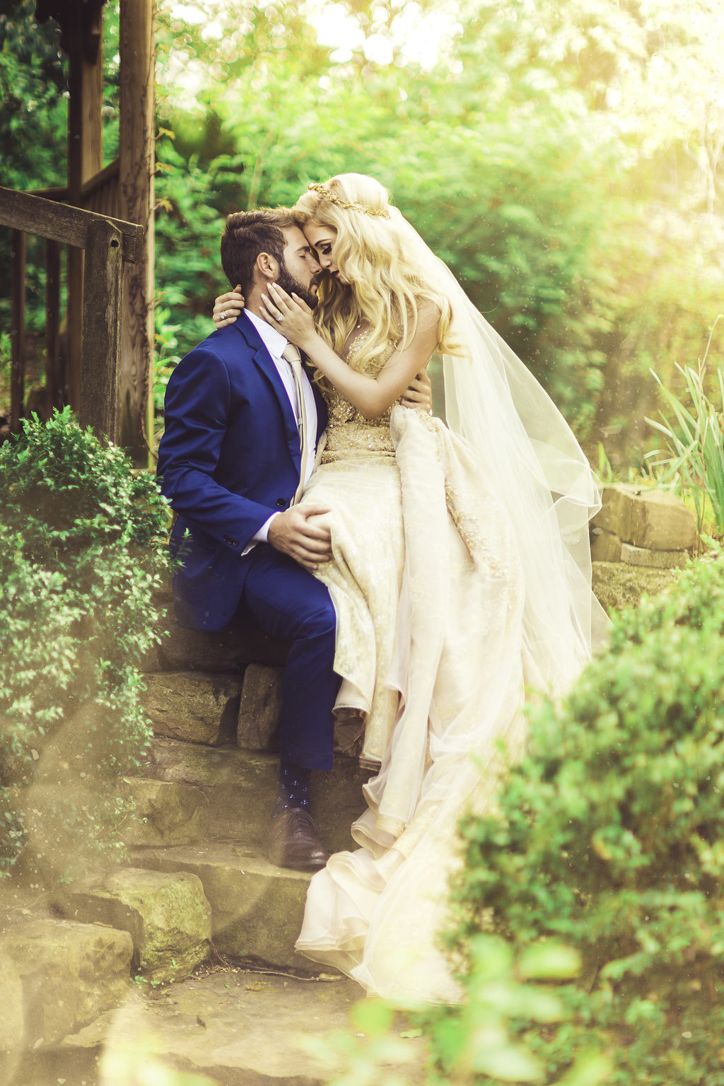 Wedding Photograph Of Bride Sitting on the Lap of Her Groom and Kissing Los Angeles