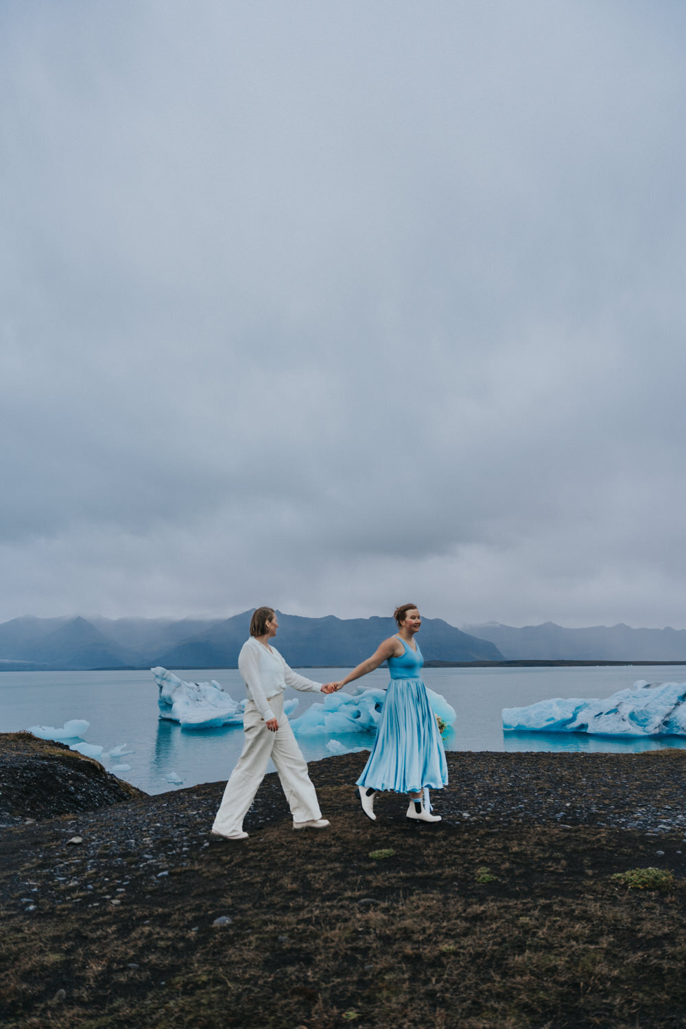 Woman leads her wife down the beach of Iceland 