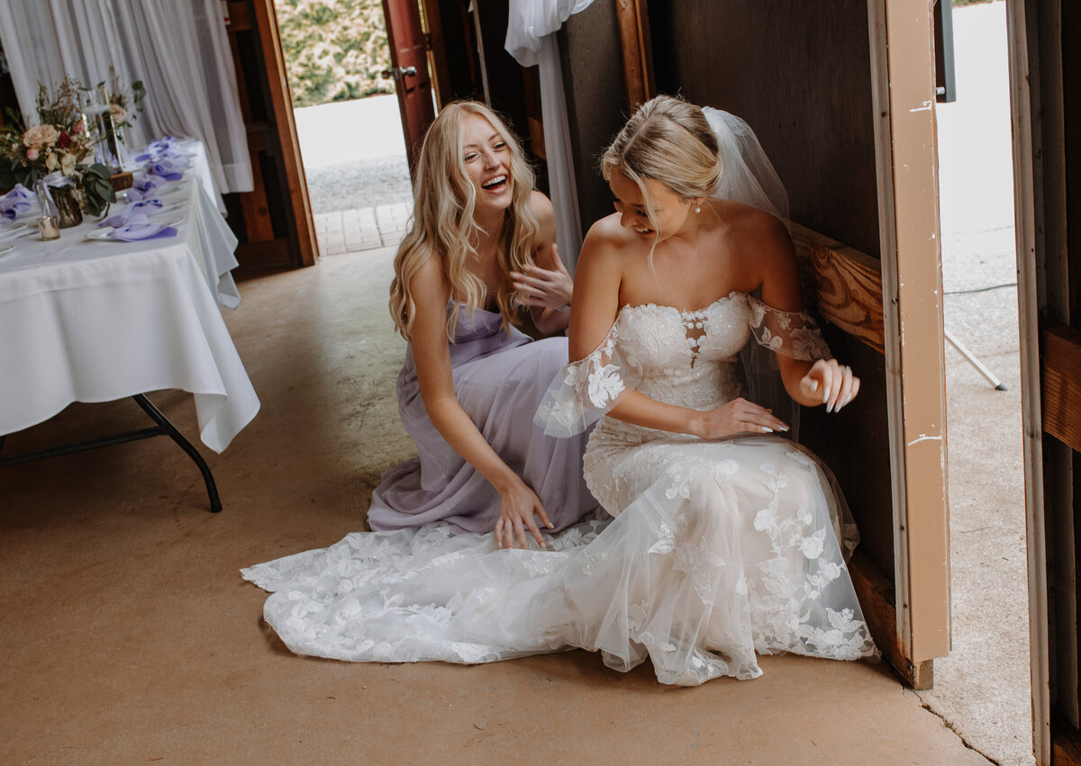 Bride and bridesmaid crouched down laughing