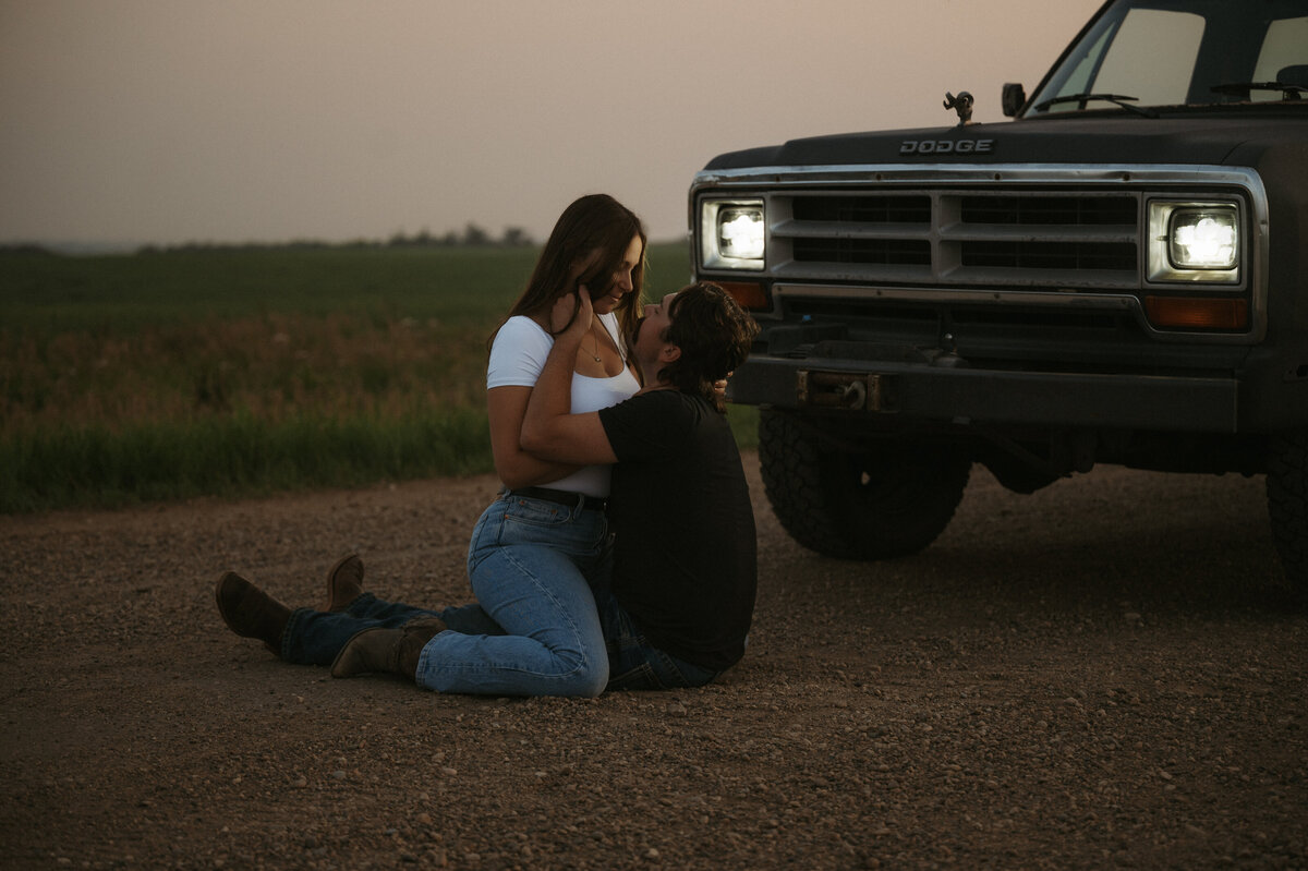 Alberta country photograph of couple sitting on dirt road with their old truck