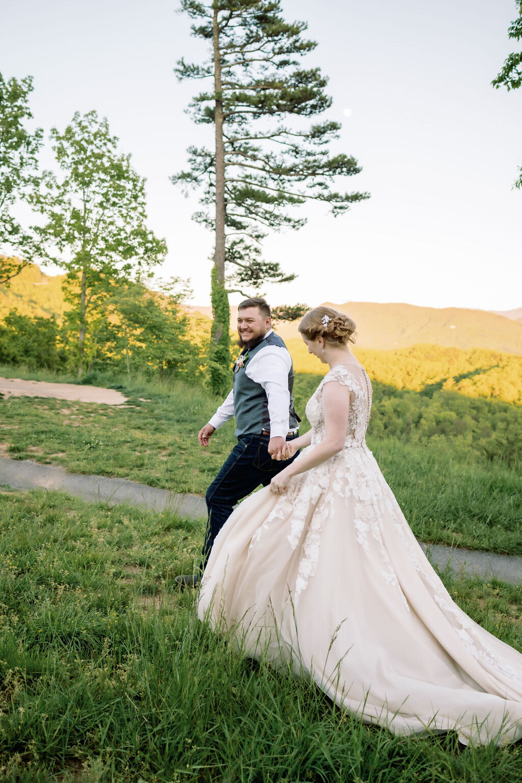 couple holding hands and walking up a hill at foothills parkway overlook