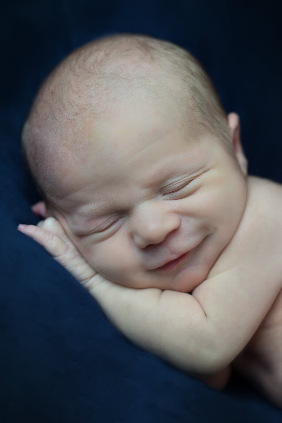 Newborn baby boy smiling and sleeping