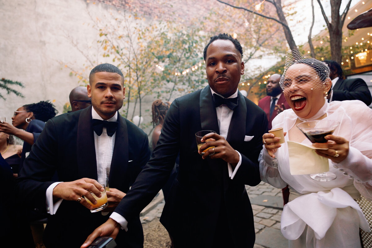 candid-photo-bride-and-groom-laugh-cocktail-hour-with-guests