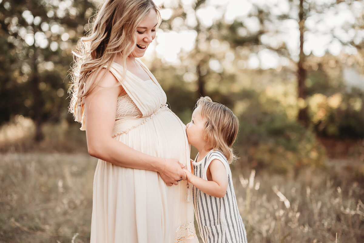 boy kissing his mom's pregnant belly