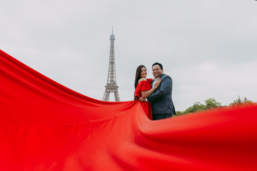 Romantic couple face to face, red dress foreground, Eiffel Tower backdrop Paris
