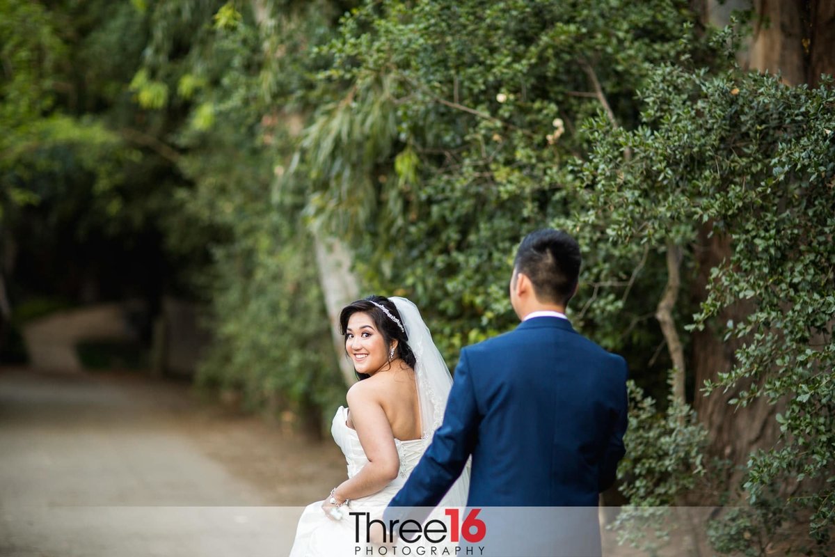 Bride looks back at her Groom in a playful moment