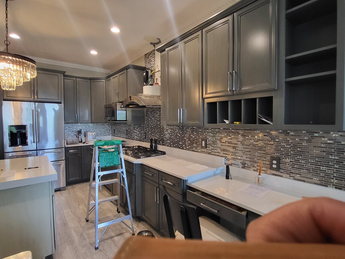 kitchen as the renovations were to take place the backsplash of glass, crystals and metal were to be removed the greenish grey cabinets to remain  along with the silestone white and grey veined countertops were also to remain